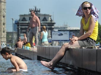 Москвичи спасаются от жары в фонтане. Фото ©AFP